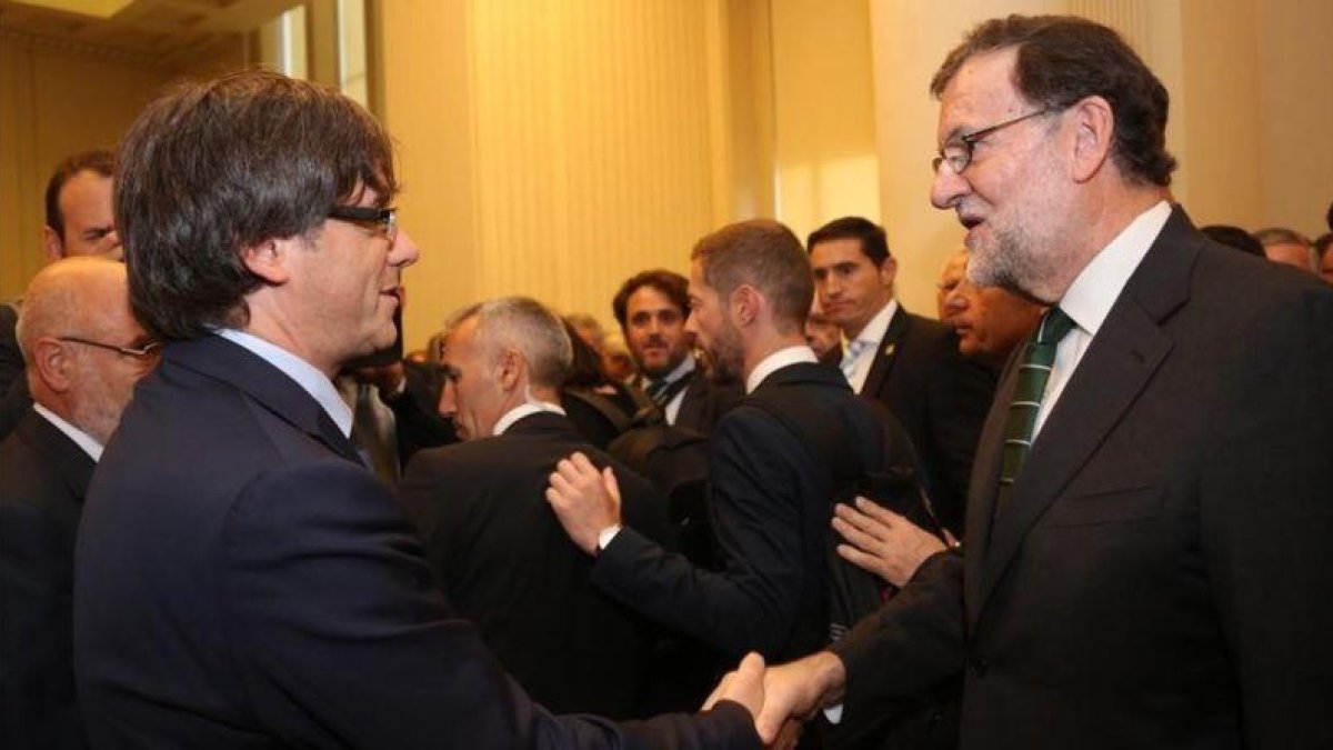El 'president' Puigdemont saluda a Rajoy durante una inauguración de una exposición sobre Joan Miró en Oporto (Portugal).-JORDI BEDMAR