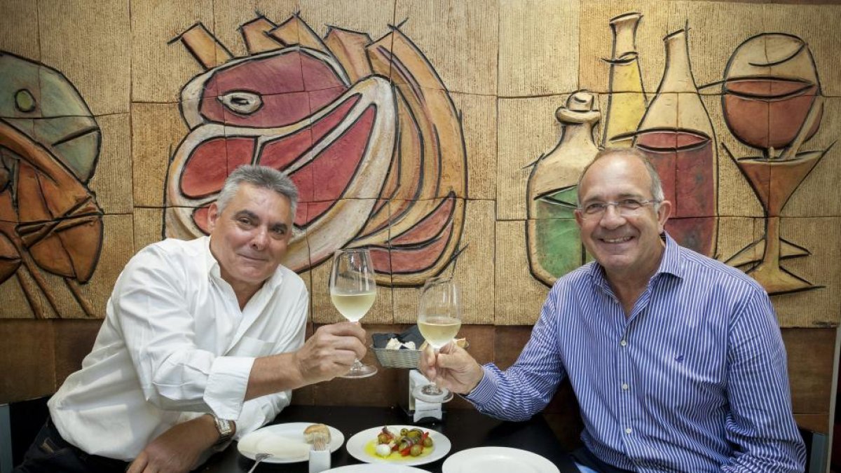 SARDINAS. Paco Espinosa (i) y José Luis López Cerrón brindan con verdejo antes de comer unas sardinas con aceite y cebolla.-Pablo Requejo
