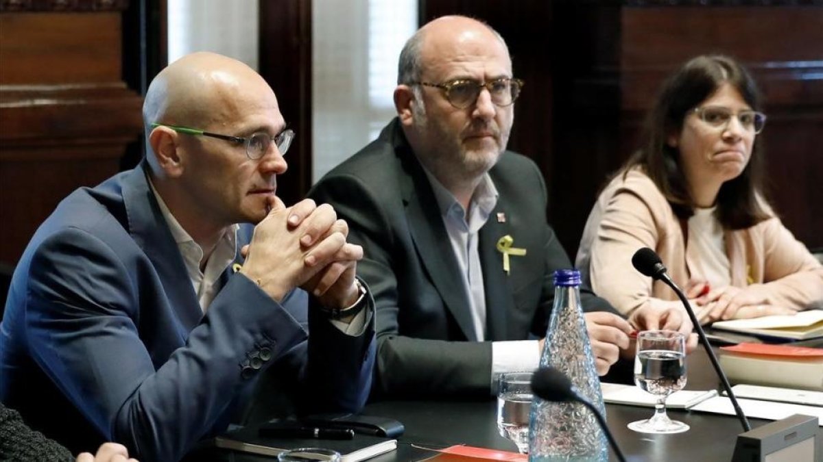 Los diputados de ERC, Raül Romeva, y JxCat, Eduard Pujol, en el Parlament.-ANDREU DALMAU (EFE)