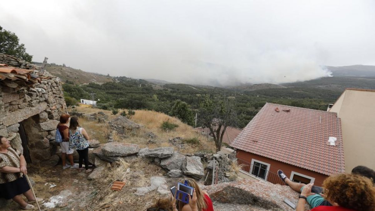 Los vecinos de Navalosa observan el incendio en la tarde de ayer.-ICAL
