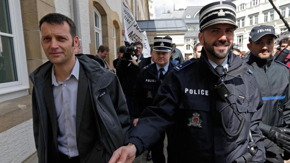 Edouard Perrin (izquierda), escoltado por la policía tras la primera jornada del juicio sobre el 'caso LuxLeaks', en Luxemburgo, este martes.-VINCENT KESSLER