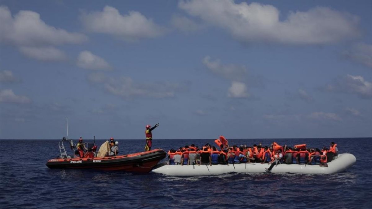 Inmigrantes esperan a ser rescatados en su atestado bote neumático por integrantes de Proactiva Open Arms, frente a las costas de Libia, el 6 de septiembre.-AP / BRAM JANSSEN