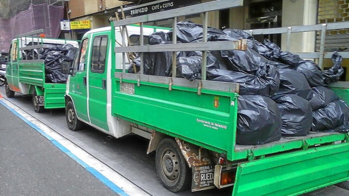 Camiones con las bolsas de basuras retiradas de la vivenda de la calle San Blas en la primera retirada.-E.M.