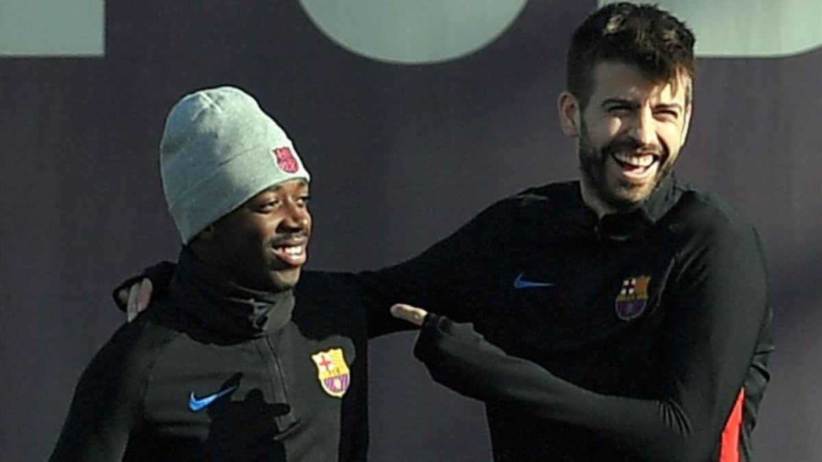 Piqué bromea con Dembélé en un entrenamiento.-LLUIS GENE
