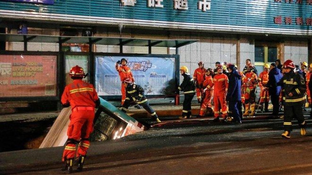 Un autobús hundido en un socavón en una parada del transporte público en la ciudad de Xining.-AFP