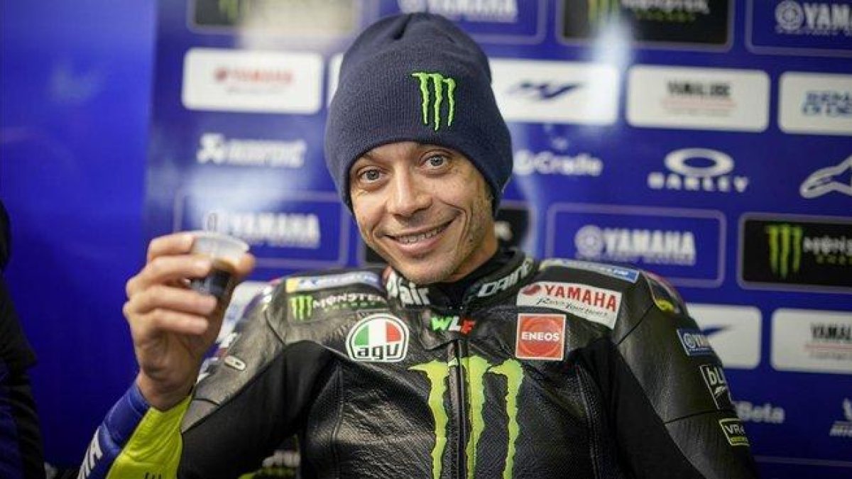 Valentino Rossi (Yamaha) simula brindar por su GP nº 400, en el boxe de Phillip Island (Australia).-MILAGRO / GIGI SOLDANO