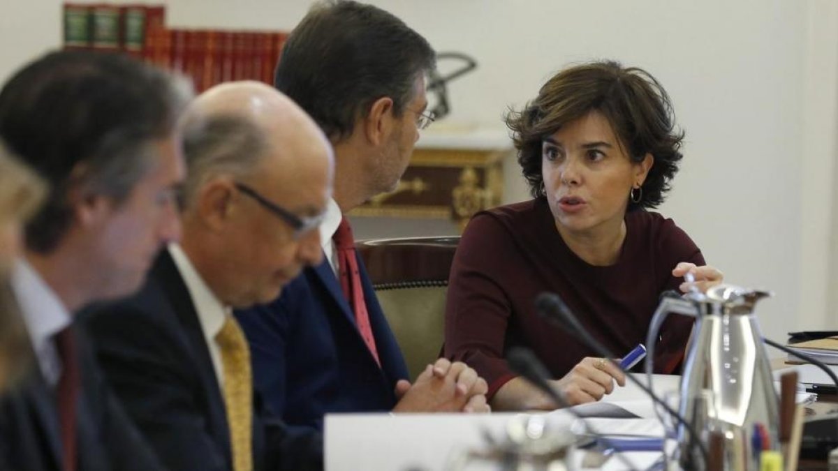 Soraya Sánez de Santamaría conversa con Rafael Catalá, junto al ministro Cristóbal Montoro e Íñigo de la Serna, este sábado, al inicio del Consejo de Ministros extraordinaro.-/ EFE / JUAN CARLOS HIDALGO
