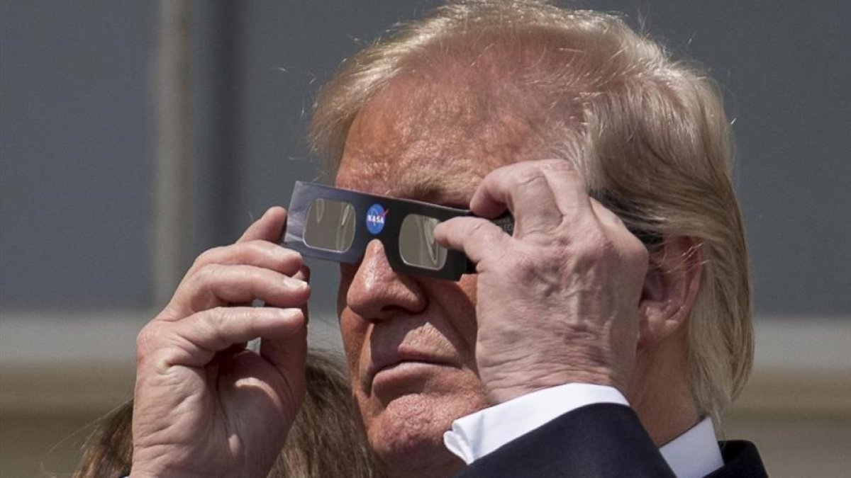 Trump se prepara para ver el eclipse de sol, en la Casa Blanca.-AP / ANDREW HAMIK