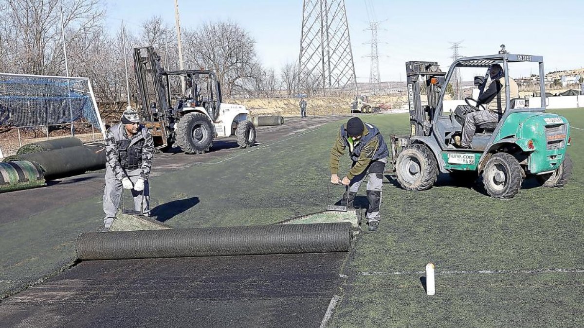 La empresa encargada de las obras en los Anexos levanta ayer la hierba artificial del segundo campo.-J. M. LOSTAU