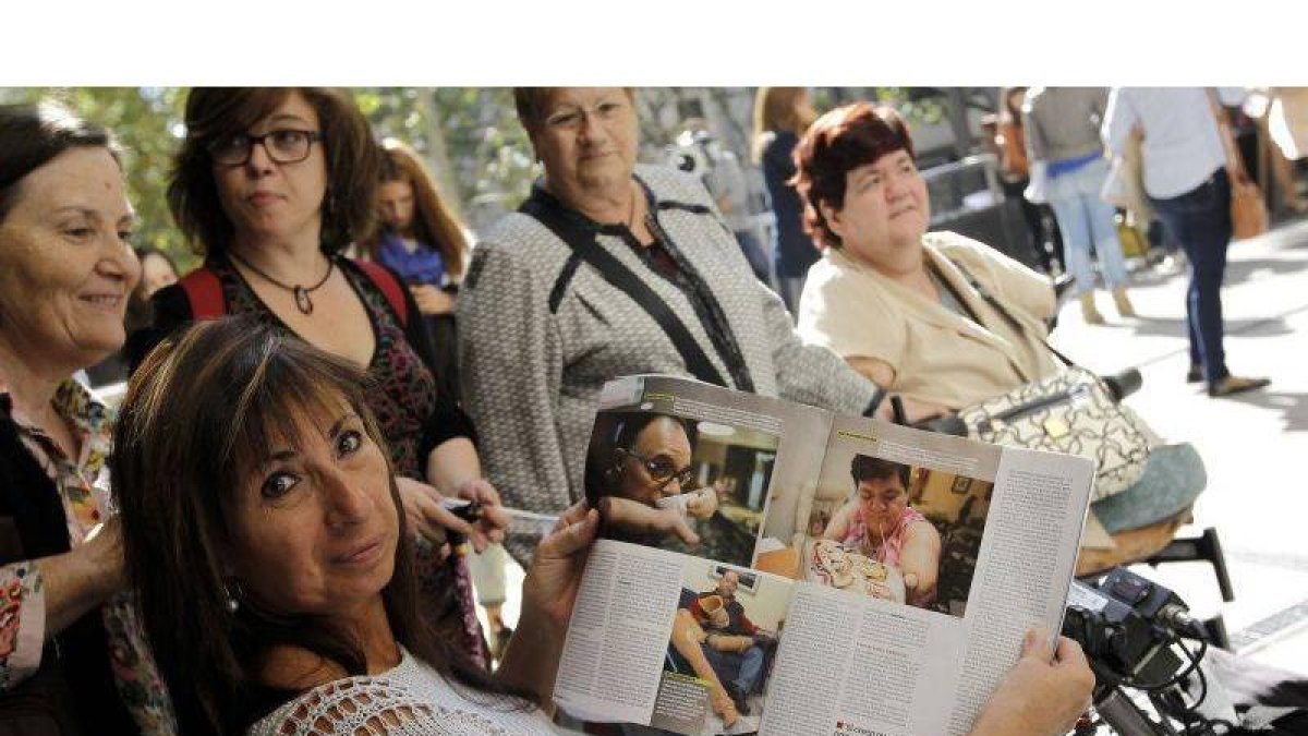 Una de las afectadas muestra el reportaje publicado esta semana por la revista Interviú momentos antes del juicio, celebrado el lunes en Madrid.-JOSÉ LUIS ROCA