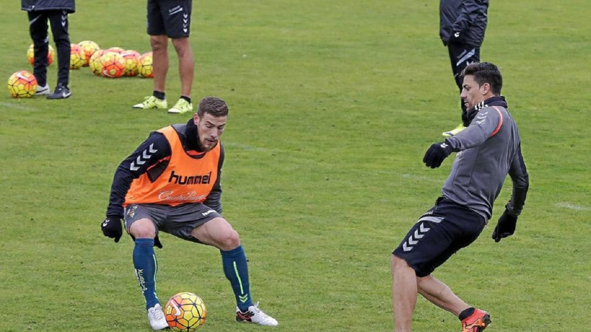 Tiba, con peto, ve pasar el balón impulsado por Óscar.-Balcaza