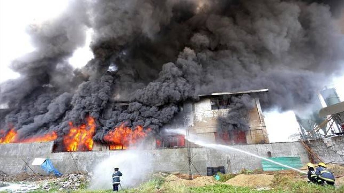 Los bomberos tratan de apagar el fuego declarado en una fábrica de zapatos de Manila.-Foto: AFP