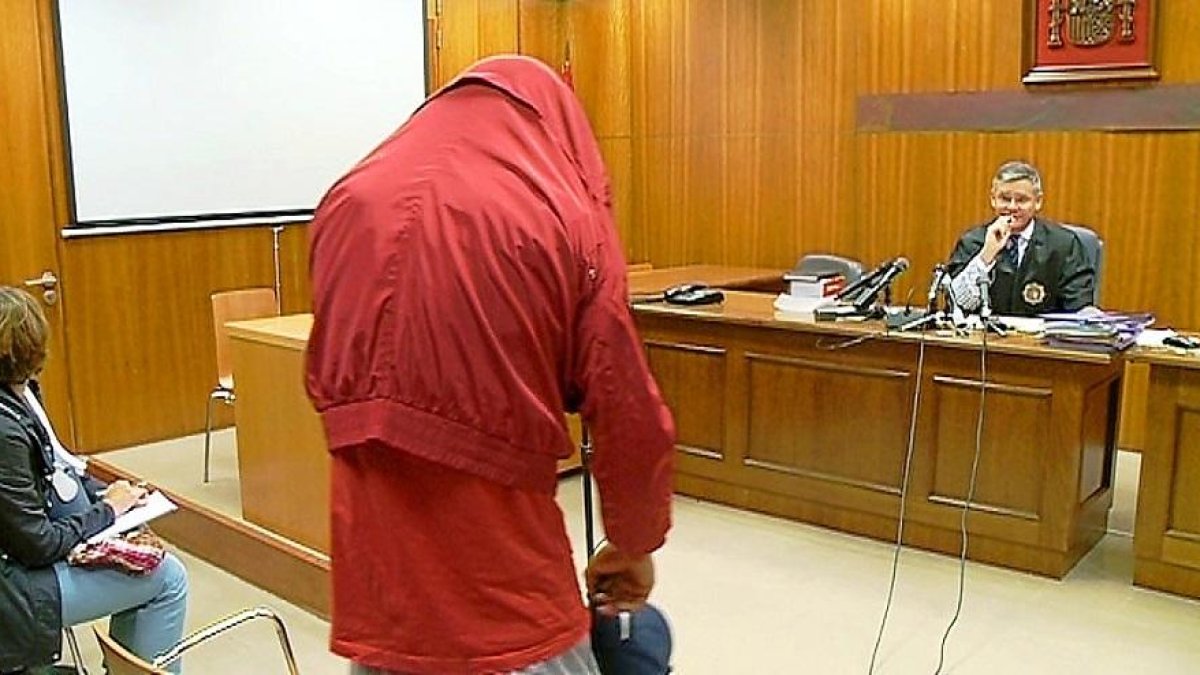 El acusado, con la cabeza escondida, escucha la sentencia de conformidad dictada por el juez.-LA 8 VALLADOLID