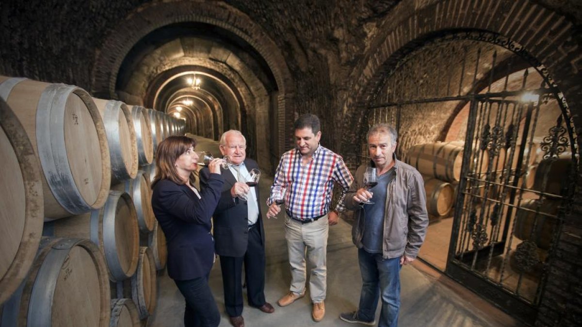 Ramón Arroyo, segundo por la derecha, posa con su padre y sus hermanos en la bodega subterránea.-E.M.