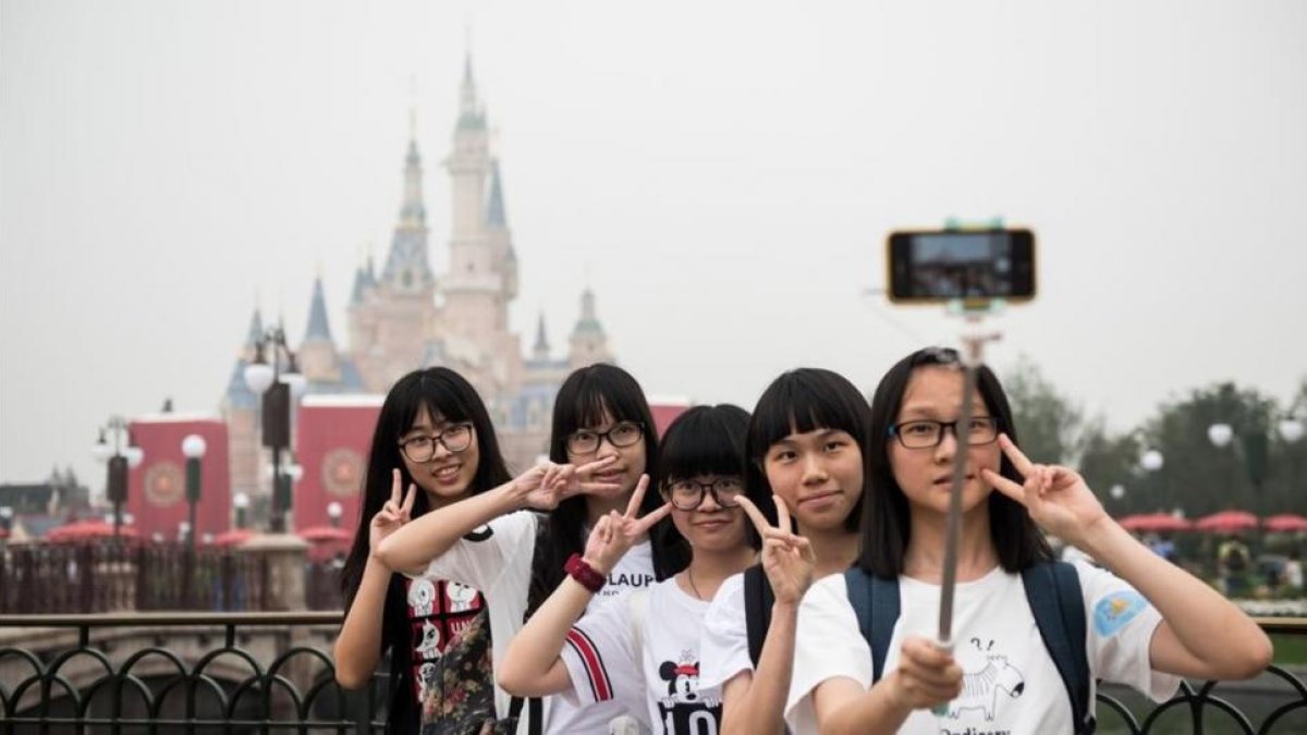 Unas visitantes al nuevo parque Disney en hacen un selfie durante la ceremonia de inauguración.-AFP / JOHANNES EISELE