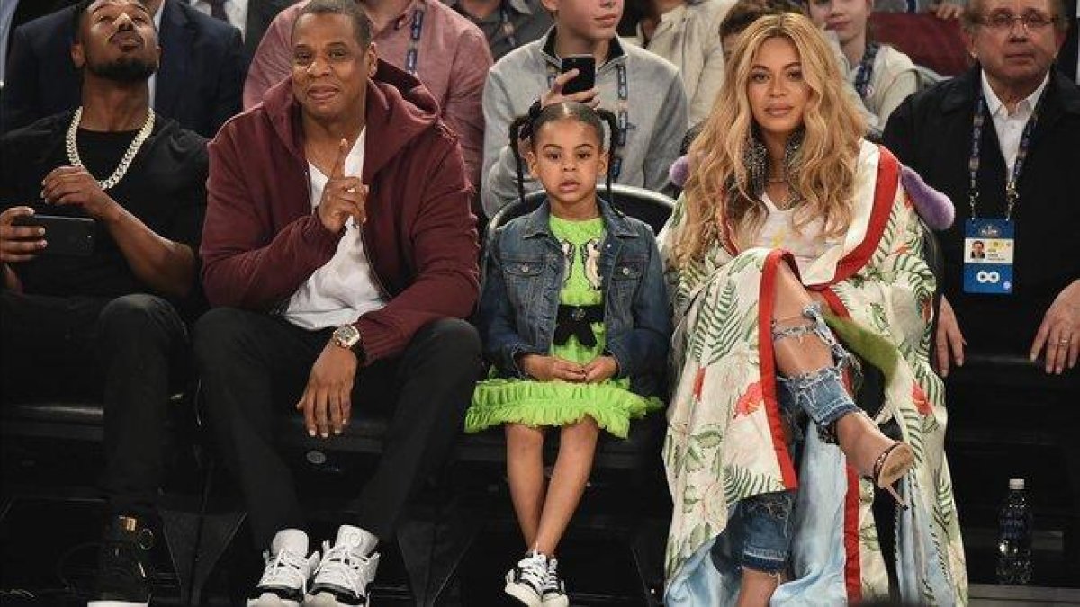 Blue Ivy, con sus padres en un partido de la NBA.-AFP