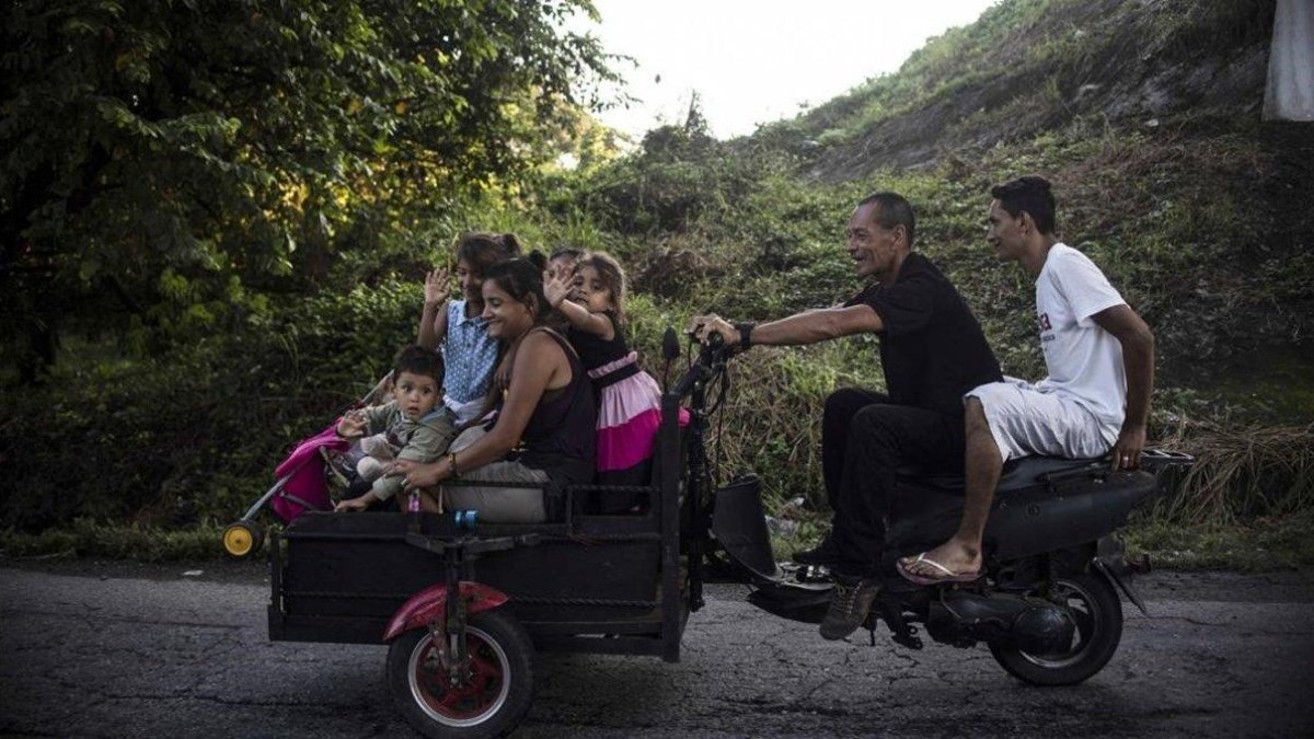 Inmigrantes hondureños montados en una moto-PEDRO PARDO / AFP