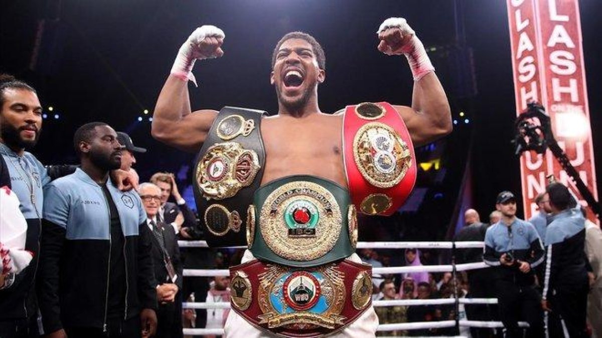Anthony Joshua celebra su victoria mostrando los tres cinturones reconquistados ante Andy Ruiz.-FAYEZ NURELDINE (AFP)