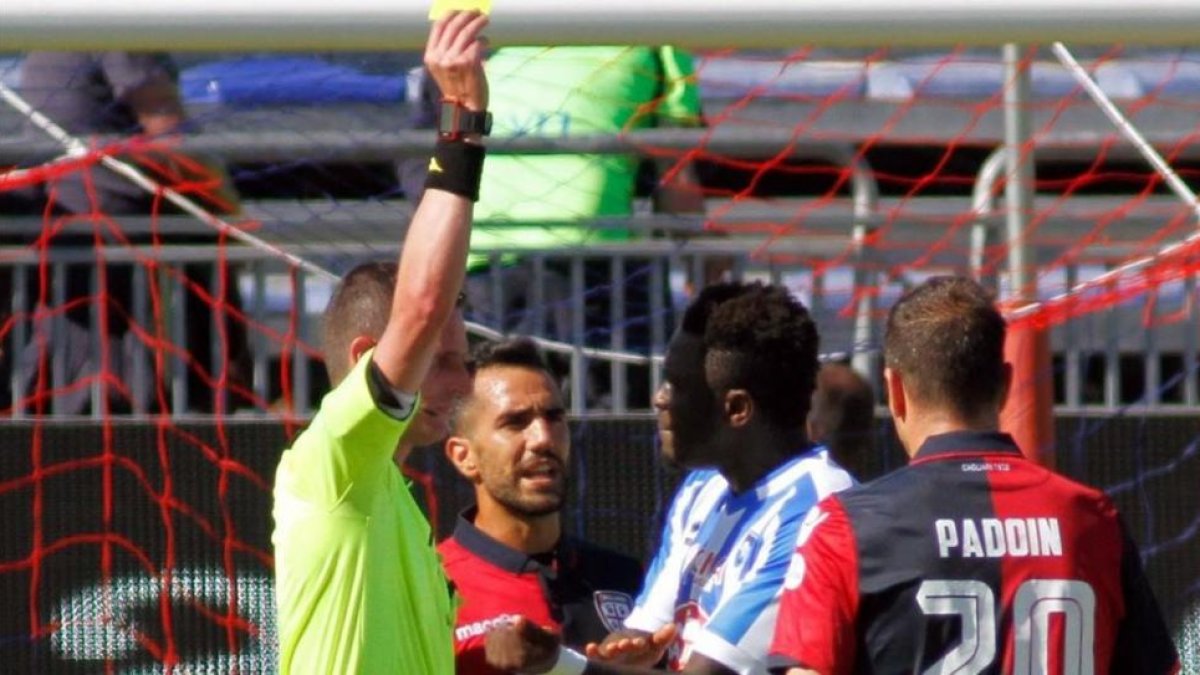 El árbitro Daniele Minelli saca la tarjeta amarilla a Muntari durante el Cagliari-Pescara del domingo.-FABIO MURRU