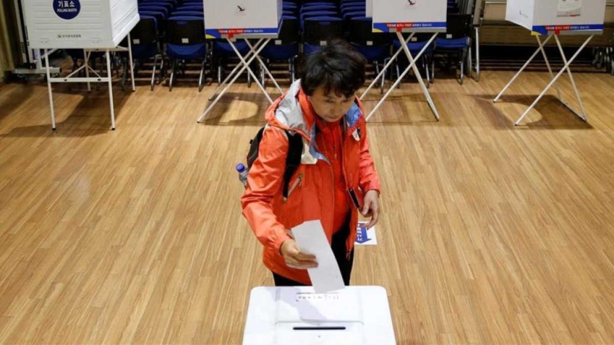 Una mujer deposita su voto en las elecciones de Corea del Sur.-KIM KYUNG-HOON / REUTERS