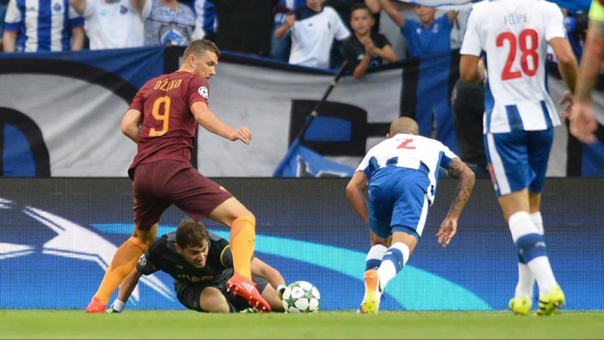 Iker Casillas no puede controlar el balón delante del bosnio Dzeko, que está a punto de marcar el 0-1 para la Roma.-MIGUEL RIOPA / AFP
