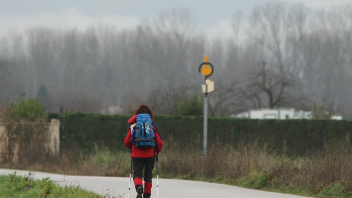 Una peregrina a su paso por Ponferrada camino de Santiago de Compostela durante el último día del año. E. M.