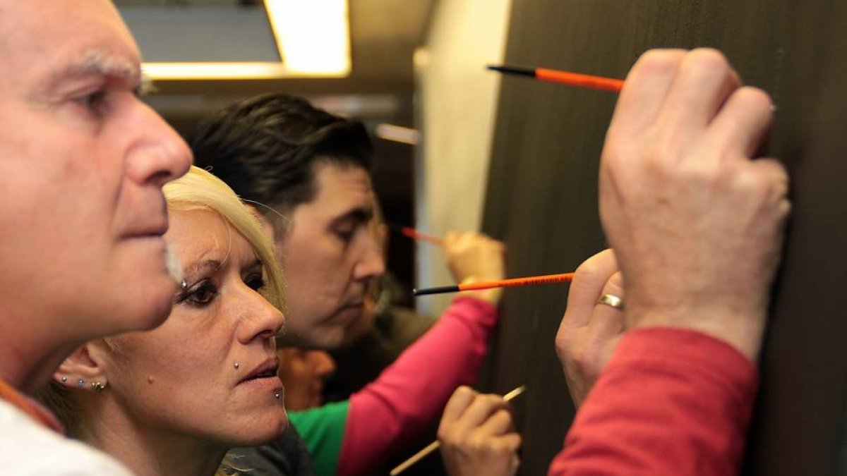 Artistas y asistentes firman el mural ‘Desahuciados en España de 2007 a 2014’-Ical
