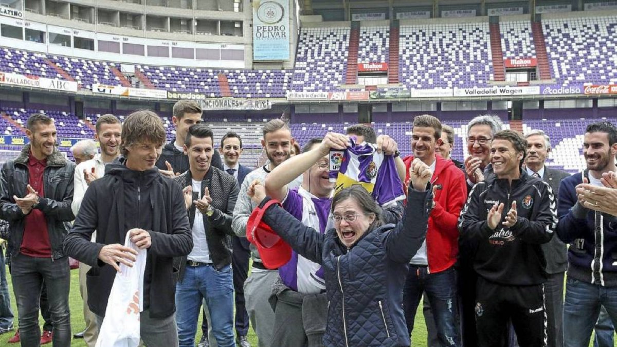 Dos jóvenes de Asprona reciben contentos una camiseta de la mano de Álvaro Rubio, capitán del Real Valladolid, junto al resto de jugadores-Ical