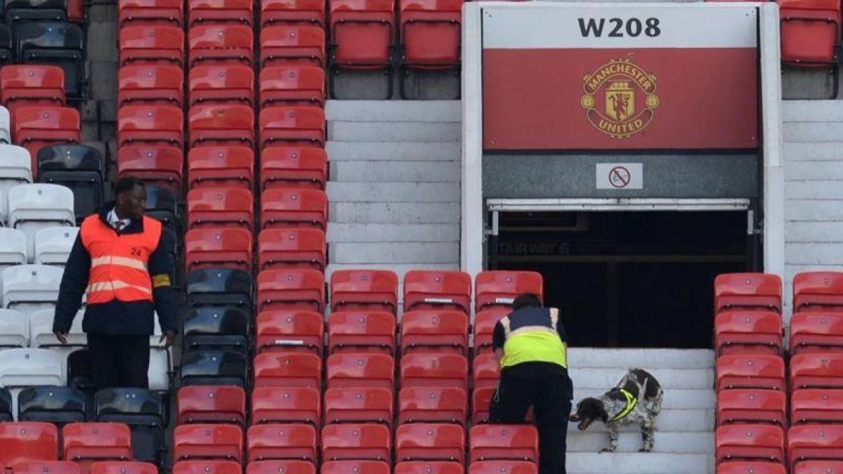 Miembros de seguridad rastrean las gradas de Old Trafford.-AFP / OLI SCARFF