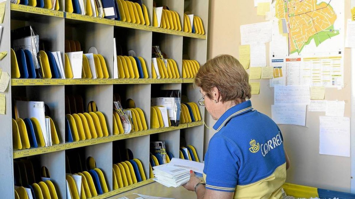En la imagen, una trabajadora de Correos clasifica la correspondencia antes de repartirla-Efe