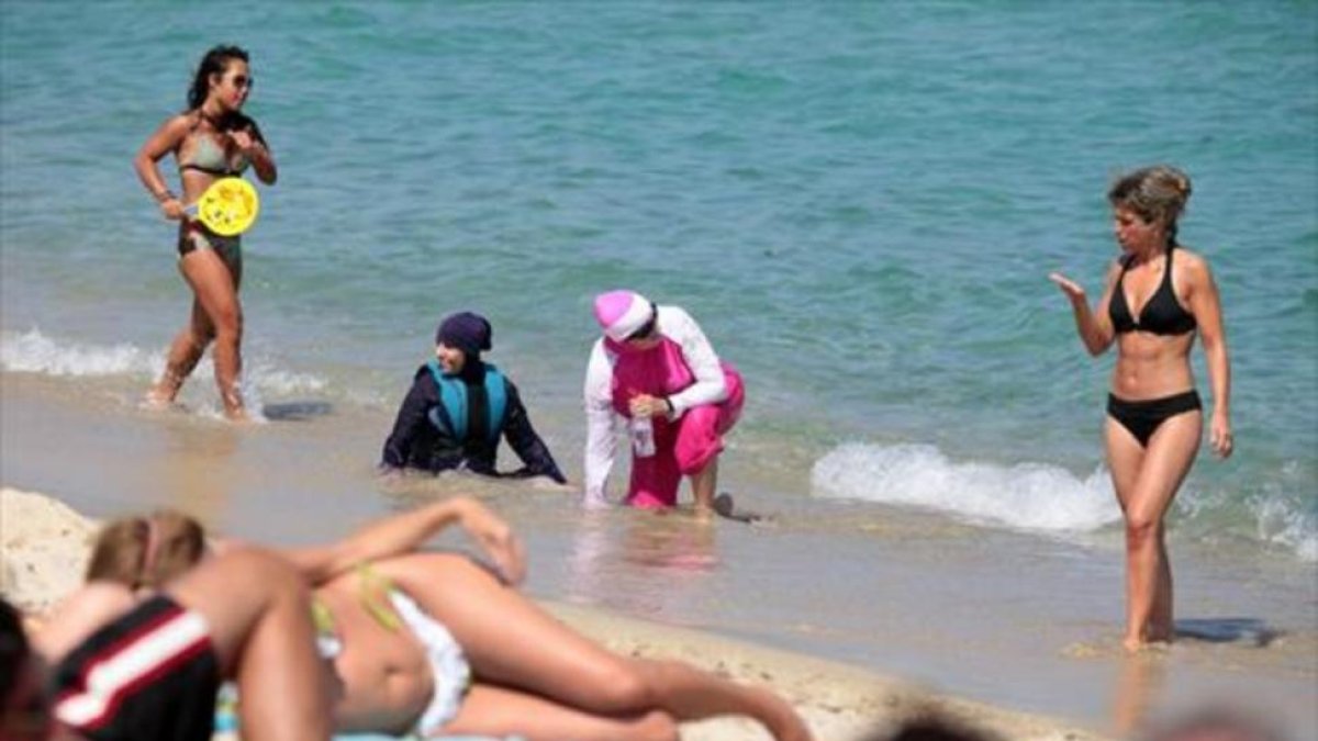 Mujeres con 'burkini' en una playa del sur de Francia, el lunes.-EFE