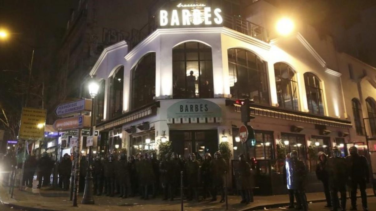 Policías antidisturbios frenta a una 'brasserie' durante la protesta contra la brutalidad policial, este miércoles, en París.-CHRISTIAN HARTMANN