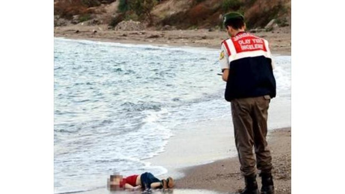 El niño sirio Aylan Kurdi, ante un guardacostas en la playa de Turquía a la que llegó su cadáver.-REUTERS / NILUFER DEMIR