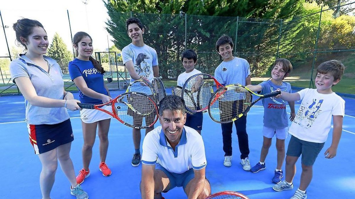 Guillermo Platel, en el centro, rodeado por varios de sus alumnos en una de las pistas del Club de Campo La Galera.-J.M. LOSTAU