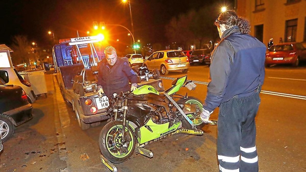 Los operarios retiran la moto tras el accidente en Madre de Dios.-J.M. LOSTAU