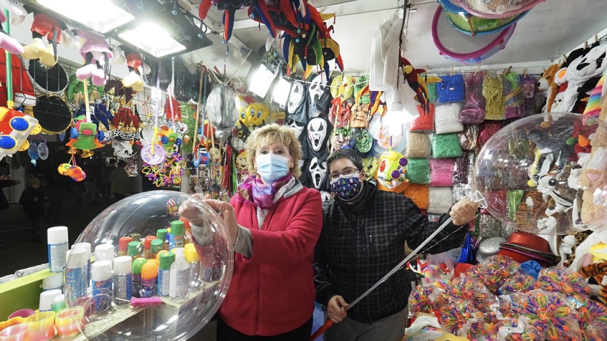 Dos feriantes posan en su puesto del rastro de Navidad de la Acera de Recoletos. PHOTOGENIC/ MIGUEL ÁNGEL SANTOS