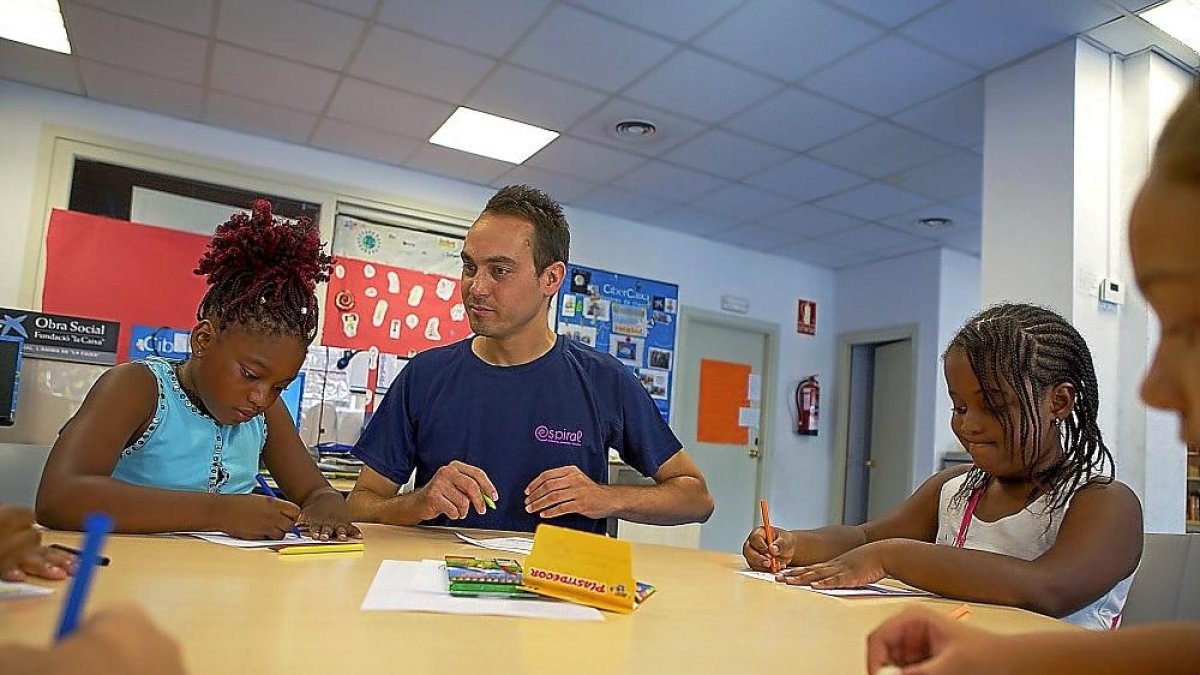 Voluntario de la Asociación Espiral con las niñas en un taller.-EL MUNDO