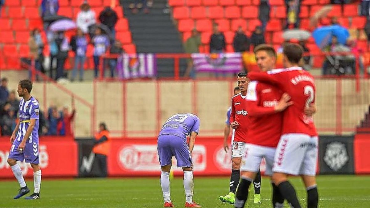 Óscar Plano, abatido mientras jugadores del Nàstic se felicitan por su gol.-PHOTO-DEPORTE