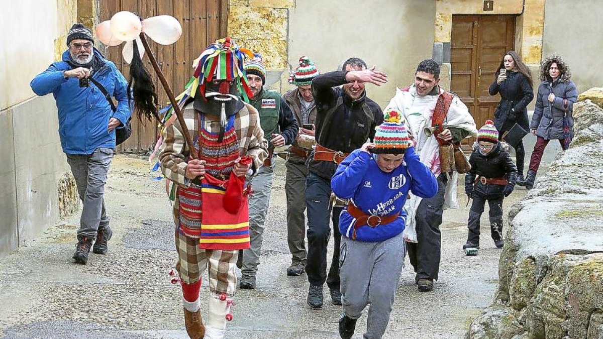 El ‘quinto’ Adrián Arribas, ataviado con la vestimenta de Zangarrón, recorre las calles de Sanzoles.-J.L. CABRERO
