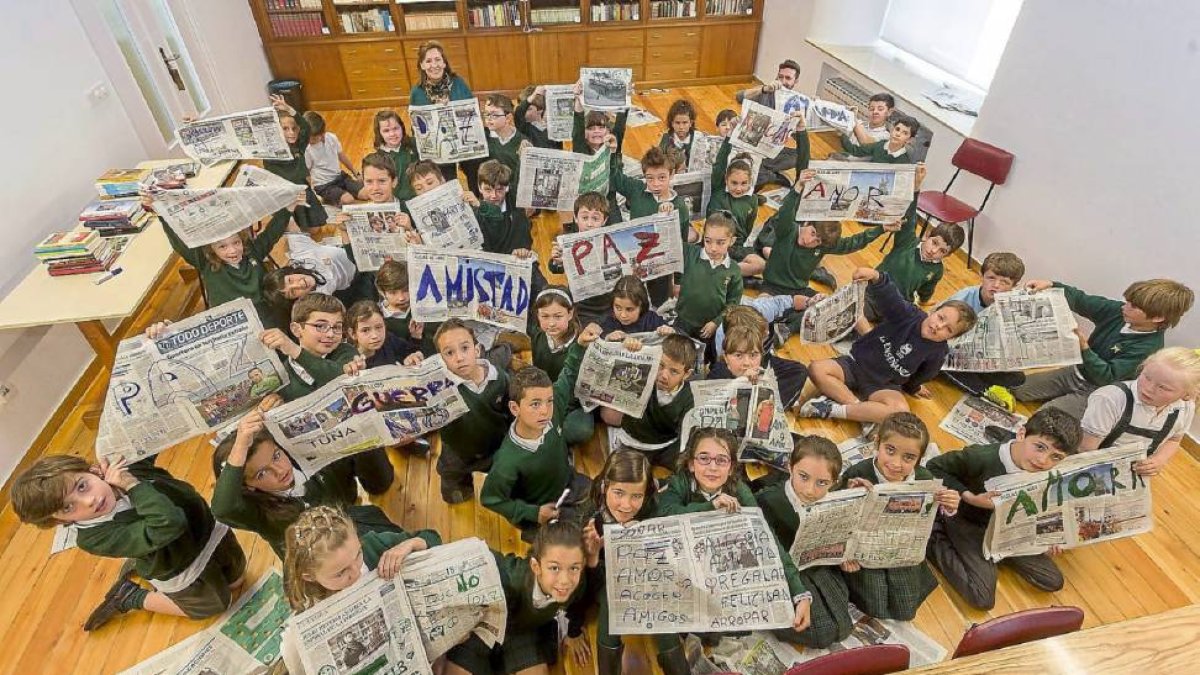 Alumnos de 2º de Primaria del colegio La Enseñanza junto con sus profesores, Trinidad de la Cal y Fernando de Diego, muestran periódicos con mensajes positivos.-Pablo Requejo