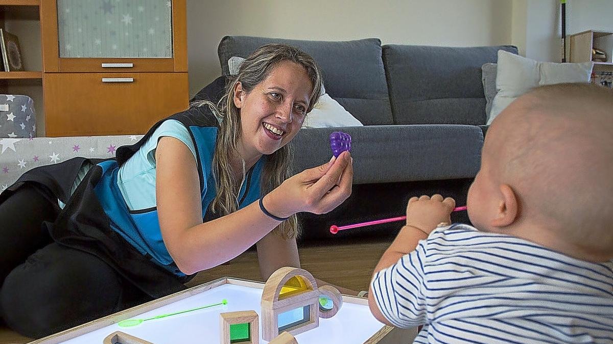 Laura juega con el pequeño Manuel, de nueve meses, alumno de su proyecto ‘La casa del colibrí’, en Santovenia de Pisuerga.-MIGUEL ÁNGEL SANTOS (PHOTOGENIC)
