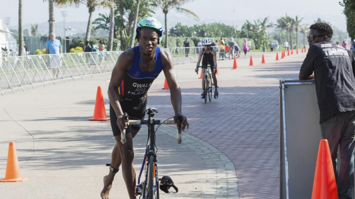 Mhlengi Gwala, el triatleta agredido, en plena transición de la bici, camino de la carrera a pie, en una foto de archivo.-/ JETHRO SNYDERS (AP)