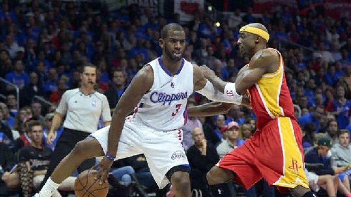 Chris Paul, de los Clippers, da un pase atrás bajo las piernas ante Jason Terry, de los Rockets.-