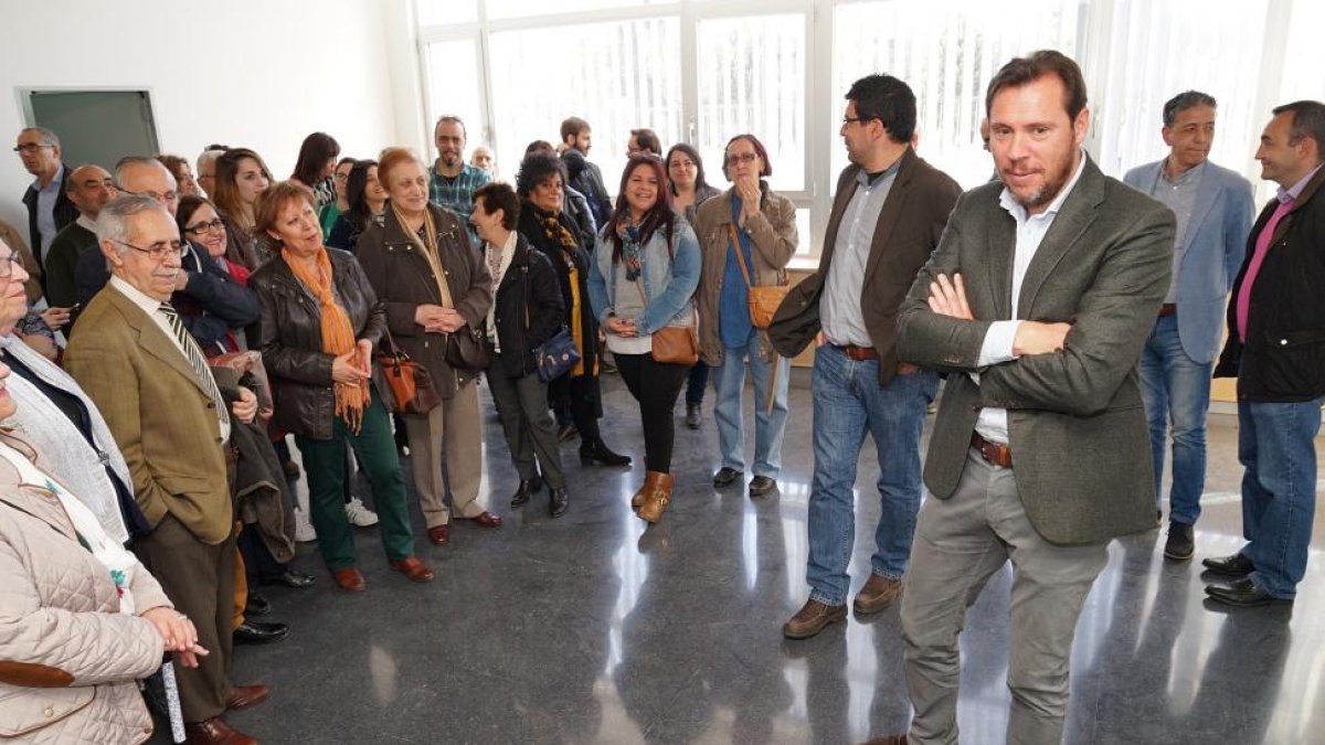 El alcalde, Óscar Puente, junto con los vecinos de La Victoria en el vestíbulo del centro cívico.-EL MUNDO