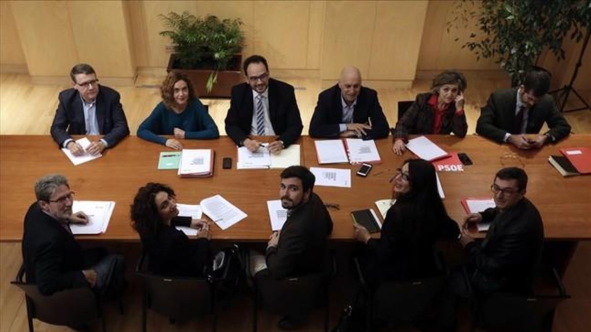 Los equipos negociadores de PSOE y de IU-Unidad Popular para la investidura de Pedro Sánchez este lunes, en su cita en el Congreso-JAVIER LIZON / EFE