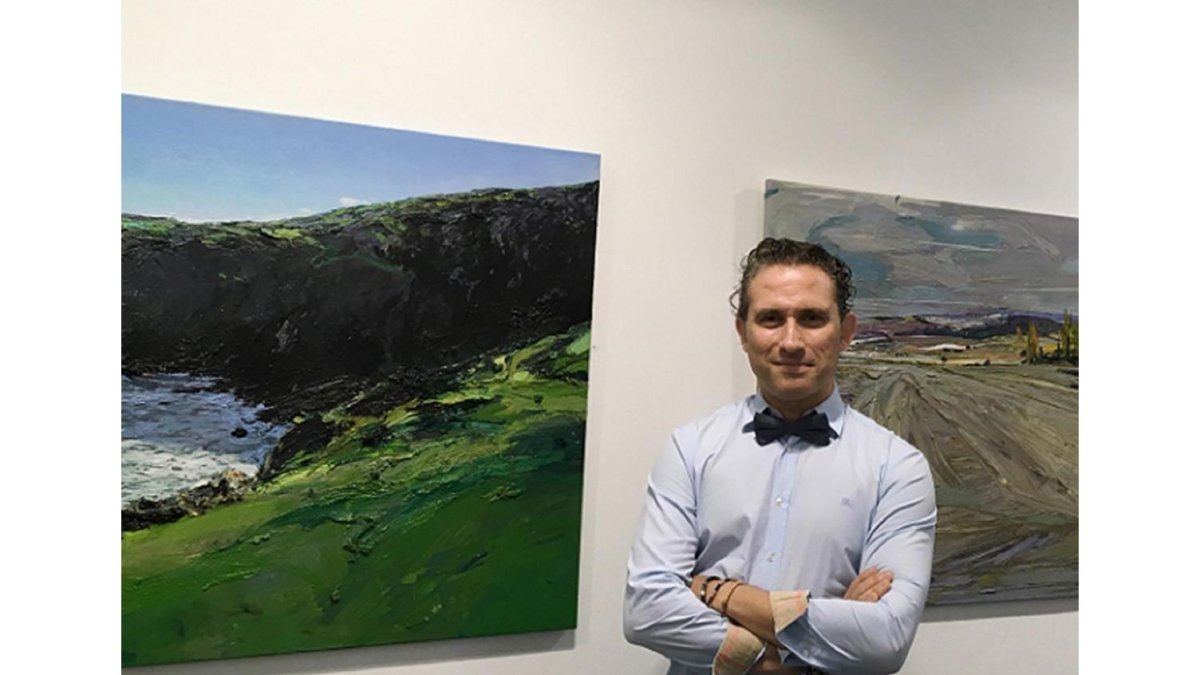 Isidoro Moreno junto a dos de los paisajes que exhibe en la Galería Espacio 36, en Zamora.-EL MUNDO