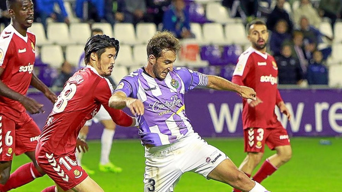 Ángel trata de llevarse el balón ante la presencia de Suzuki en el Valladolid-Nàstic.-J.M. LOSTAU