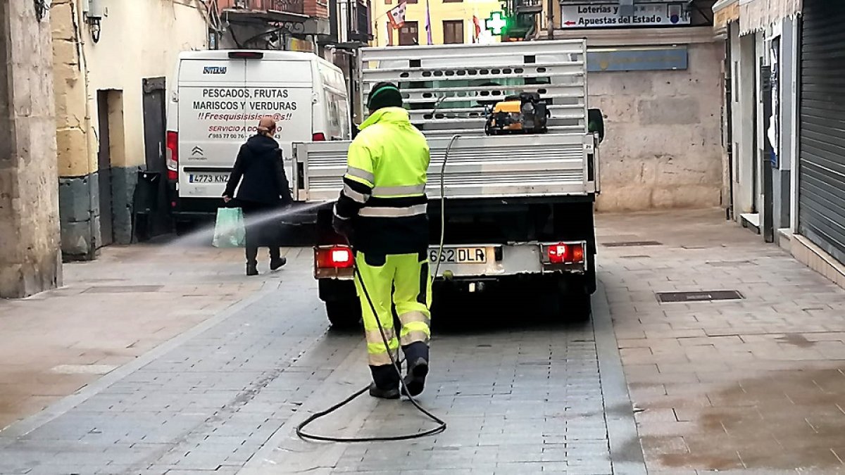 Un operario desinfecta con una manguera la céntrica calle de Santa María de Tordesillas, ayer. - EL MUNDO
