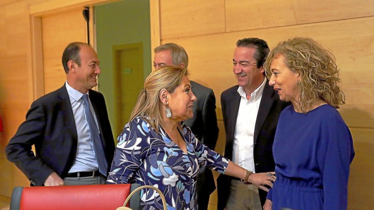 La fiscal Lourdes Rodríguez conversa con Rosa Valdeón antes de presentar la memoria ayer en las Cortes.-ICAL