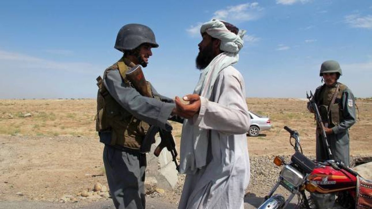 Un policía afgano cachea a un ciudadano en un punto de control en la ciudad de Lashkar Gah tras la fin del proceso de paz.-Foto: AFP / NOOR MOHAMMAD